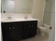 Well-lit bathroom featuring double sink vanity with dark wood cabinets at 4830 Cazes Ave, North Port, FL 34287