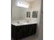 Bathroom featuring double sinks with a large mirror and dark vanity at 4830 Cazes Ave, North Port, FL 34287