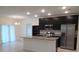 Spacious kitchen featuring dark cabinets, stainless steel appliances, and an island with seating at 4830 Cazes Ave, North Port, FL 34287