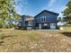 Backyard features a large grass area with a hot tub, a deck, and mature trees at 6421 Grove Blvd, Punta Gorda, FL 33982