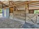 Interior of a barn featuring wooden stalls, metal gates, and a concrete base at 6421 Grove Blvd, Punta Gorda, FL 33982