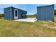 Exterior view of storage containers, patio, and grassy lawn at 6421 Grove Blvd, Punta Gorda, FL 33982