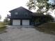Two-story home featuring a two-car garage and a second-story balcony with mature trees surrounding the property at 6421 Grove Blvd, Punta Gorda, FL 33982