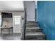Stylish staircase with gray tile floors leading to a doorway and a spacious landing with a TV at 6421 Grove Blvd, Punta Gorda, FL 33982