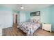 A lovely bedroom featuring a decorative quilt, light wood floors, and cool, light blue-painted walls at 1080 Bal Harbor Blvd # 12C, Punta Gorda, FL 33950