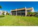 Back exterior view of condo building with screened in balconies and meticulously maintained lawn at 1080 Bal Harbor Blvd # 12C, Punta Gorda, FL 33950