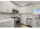 Bright kitchen featuring white cabinets, stainless steel appliances, and stylish countertops at 1080 Bal Harbor Blvd # 12C, Punta Gorda, FL 33950