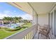 Balcony view overlooking a sparkling pool, lush landscaping, and sunny skies at 1080 Bal Harbor Blvd # 12C, Punta Gorda, FL 33950