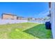 Fenced backyard featuring lush green grass and a view of neighboring homes at 111 Rain Lily Ave, Spring Hill, FL 34609