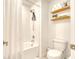 Bathroom featuring shower over bath, toilet and shelves at 111 Rain Lily Ave, Spring Hill, FL 34609