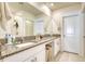 Bathroom with double granite vanity, framed mirror, and shower with gray stone countertops at 111 Rain Lily Ave, Spring Hill, FL 34609