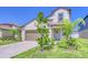 Charming two-story home with a well-manicured lawn and a welcoming front entrance with a wreath at 111 Rain Lily Ave, Spring Hill, FL 34609