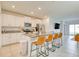 Well-lit kitchen with stainless steel appliances, white cabinets, and a granite island with seating at 111 Rain Lily Ave, Spring Hill, FL 34609