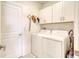 Functional laundry room equipped with modern washer and dryer and lots of storage at 111 Rain Lily Ave, Spring Hill, FL 34609