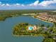 Stunning aerial view of lush landscaping, community pool, and amenities nestled on an island in a serene lake at 11666 Parrotfish St, Venice, FL 34292