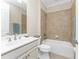 Bathroom features a tub and shower with tile surround and a vanity with a white countertop and cabinets at 11666 Parrotfish St, Venice, FL 34292