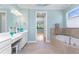 Bright bathroom featuring a soaking tub, double vanity sink, and neutral wall paint at 11666 Parrotfish St, Venice, FL 34292