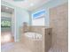 Bright bathroom featuring a soaking tub and glass enclosed shower with tiled walls at 11666 Parrotfish St, Venice, FL 34292