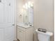 This bathroom features a toilet, a sink with vanity, beige walls, and white doors and trim at 11666 Parrotfish St, Venice, FL 34292