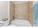 This bathroom features a tiled shower and tub, white toilet, and blue towels at 11666 Parrotfish St, Venice, FL 34292