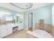 Bright bathroom featuring a soaking tub, double vanity sink, and neutral wall paint at 11666 Parrotfish St, Venice, FL 34292