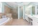 Bright bathroom featuring a soaking tub, walk-in shower, and double vanity sink at 11666 Parrotfish St, Venice, FL 34292