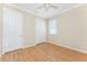 This bedroom has wood-look floors, neutral walls, white doors, a ceiling fan, and a window with blinds at 11666 Parrotfish St, Venice, FL 34292