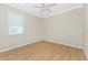 Bedroom features a ceiling fan, window with blinds, wood-look floors, and neutral walls at 11666 Parrotfish St, Venice, FL 34292