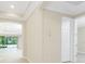 Hallway with beige walls and neutral tile flooring leading into an open-concept living area at 11666 Parrotfish St, Venice, FL 34292