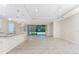 Open-concept living room with neutral tile flooring, tray ceilings and sliding glass doors to screened-in patio at 11666 Parrotfish St, Venice, FL 34292