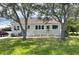 Quaint single-story house with a large porch, nestled amidst mature trees and lush greenery at 1250 Lemon St, Punta Gorda, FL 33950