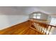 Bright upstairs hallway with wood railing and floors, with a cozy, sunlit nook at 1250 Lemon St, Punta Gorda, FL 33950