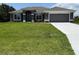Charming single story home featuring a two car garage, manicured lawn, and a covered entryway at 13346 High Springs Ave, Port Charlotte, FL 33981