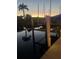 Scenic dock view showcases palm tree, sailboat, and calm waters reflecting the sunset sky at 155 Donna Ct, Punta Gorda, FL 33950