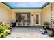 Inviting covered front porch with seating and a view of the home's lush landscaping at 155 Donna Ct, Punta Gorda, FL 33950
