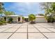 Charming single-story home featuring an expansive paved driveway and lush tropical landscaping at 155 Donna Ct, Punta Gorda, FL 33950