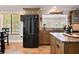 Modern kitchen showcasing stainless steel refrigerator, tile flooring and countertops, and ample cabinet space at 155 Donna Ct, Punta Gorda, FL 33950