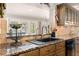 Kitchen sink features granite countertops, tile backsplash, stainless steel appliances, and view to the backyard at 155 Donna Ct, Punta Gorda, FL 33950