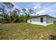 Expansive backyard featuring newly constructed home and lush trees offering plenty of space for outdoor activities at 16218 Chamberlain Blvd, Port Charlotte, FL 33954