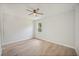 Comfortable bedroom featuring a lighted ceiling fan, neutral paint, wood-look flooring, and bright window at 16218 Chamberlain Blvd, Port Charlotte, FL 33954