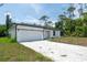 Exterior view of a single-story home showcasing a well-maintained front yard and a paved driveway at 16218 Chamberlain Blvd, Port Charlotte, FL 33954