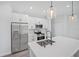 A modern kitchen featuring stainless steel appliances, white cabinets, and a quartz-topped island at 16218 Chamberlain Blvd, Port Charlotte, FL 33954