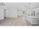 Open-concept living space with a kitchen island, modern lighting, wood-look floors, and neutral paint at 16218 Chamberlain Blvd, Port Charlotte, FL 33954