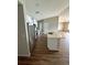 Modern kitchen with stainless steel appliances, white cabinets, an island with a sink, and sleek wood flooring at 16280 Minorca Dr, Punta Gorda, FL 33955