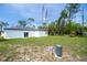 A view of the backyard showcasing a well-maintained lawn and functional well pump and plumbing at 17197 Russell Ave, Port Charlotte, FL 33954