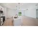 The open-concept kitchen boasts white cabinets, a large island with sink, and stainless steel appliances at 17197 Russell Ave, Port Charlotte, FL 33954