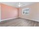 This bedroom offers new flooring, a ceiling fan, and a window overlooking the front yard at 19468 Edgewater Dr, Port Charlotte, FL 33948