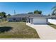 Charming single story home featuring a well-maintained yard, attached two-car garage, and neutral paint scheme at 19468 Edgewater Dr, Port Charlotte, FL 33948
