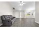 Cozy living room with gray tile floors, neutral walls, a ceiling fan, and a comfortable gray leather sofa at 19468 Edgewater Dr, Port Charlotte, FL 33948