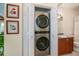 Modern stainless steel stackable washer and dryer in closet near vanity with artwork on the walls at 2060 Willow Hammock Cir # 301, Punta Gorda, FL 33983